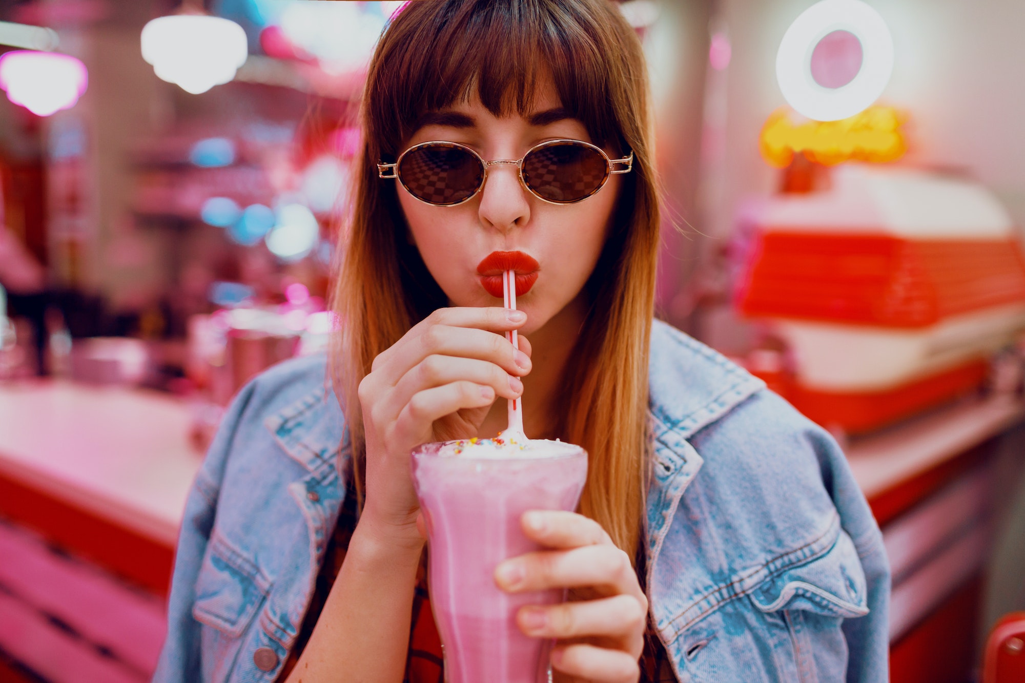 Close up fashion portrait of stylish brunette woman drinking tasty sweet milk shake