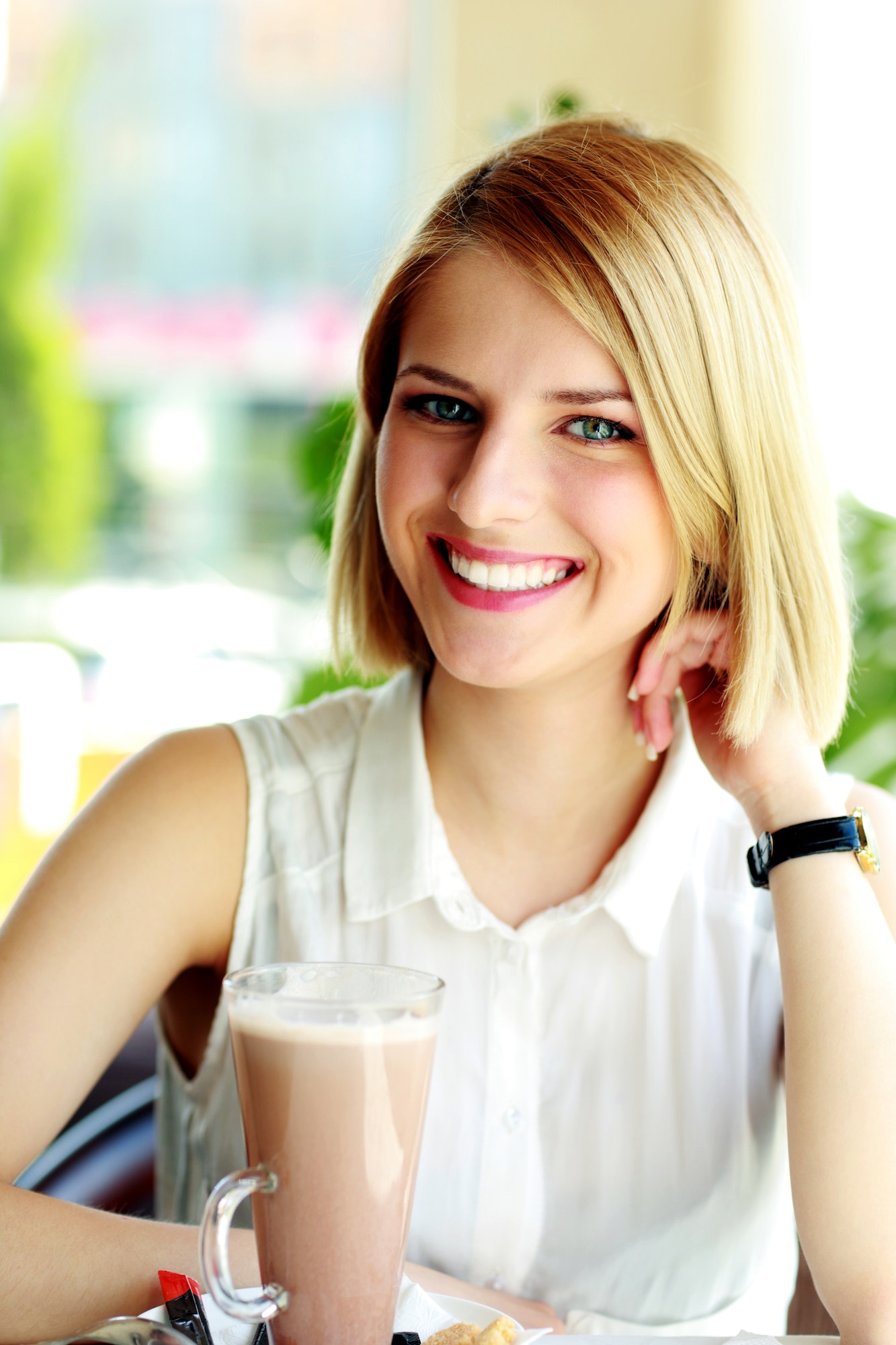Young smiling woman sitting in cafe